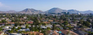 Aerial view of Fontana, California, showcasing a residential neighborhood with a backdrop of mountains and urban developments.